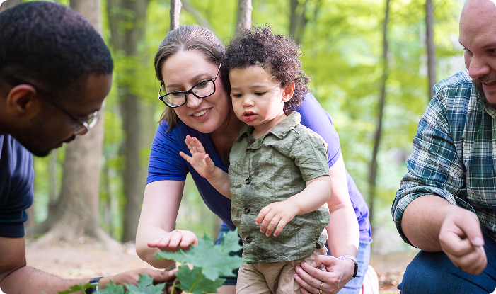 Family and volunteer exploring nature together