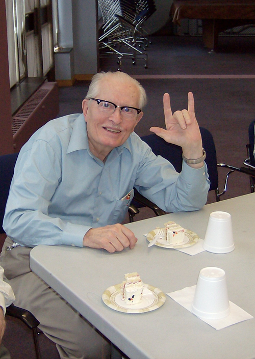 Elderly man posing for picture using sign language
