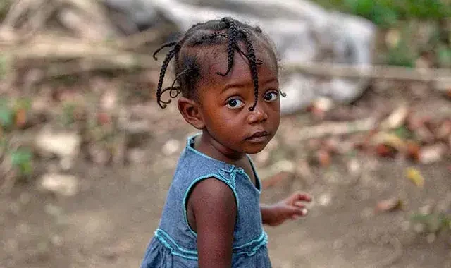 a little girl looking at the camera - hurricane-matthew-appeal-2016-mobile - Humanitarian Coalition